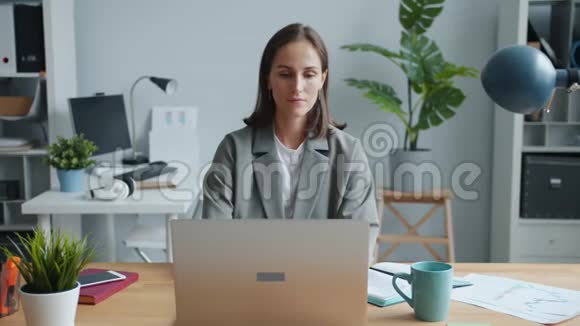 女性办公室工作人员使用笔记本电脑然后在工作场所喝茶放松视频的预览图