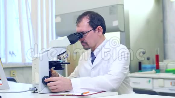 化验师科学家在科学实验室进行实验用显微镜进行研究尤里卡视频的预览图