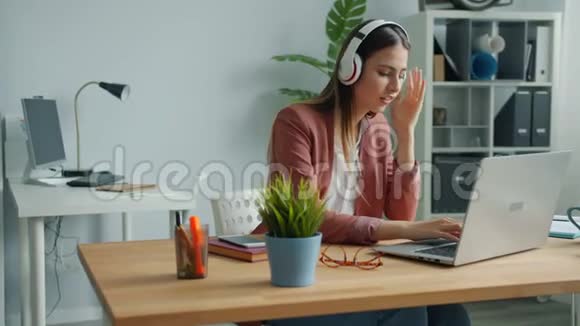 工作中听音乐唱歌和使用电脑的开朗的经理视频的预览图