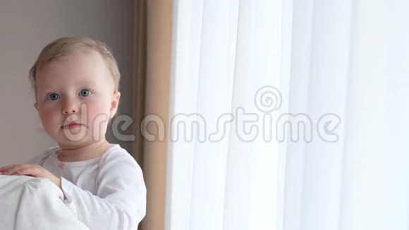 她妈妈怀里的小女孩靠近窗户视频的预览图