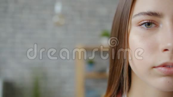 公寓里站在砖墙上的漂亮女士半张脸的慢镜头肖像视频的预览图