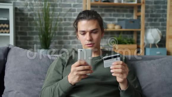 快乐的年轻人用信用卡和智能手机在线购物视频的预览图