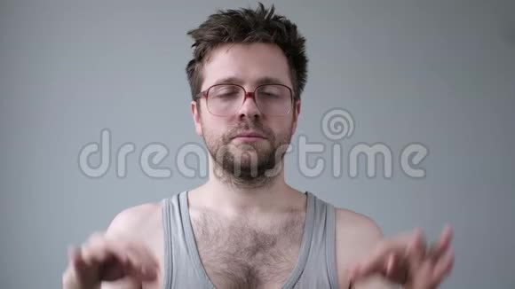 聚精会神的长胡子男人戴着大眼镜沉思试着放松让手指保持在一起视频的预览图