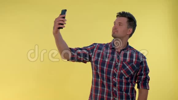 漂亮的高个子男孩在智能手机上自拍视频的预览图