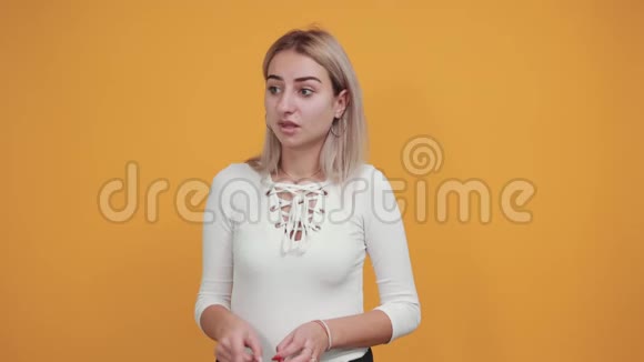 穿着休闲衬衫的漂亮女人在工作空间里保持双手脸颊视频的预览图