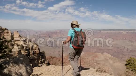 徒步旅行的女人走在大峡谷悬崖的边缘举起双手成功视频的预览图