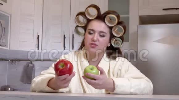 另外一个穿着浴袍头上有卷发的大女孩看着苹果不想吃视频的预览图