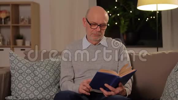 秃顶的老人坐在沙发上看书视频的预览图