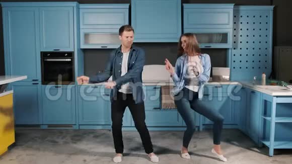 家庭舞会快乐年轻夫妇在家厨房做饭时跳舞很有趣迪斯科舞曲视频的预览图
