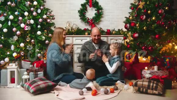 新的一年在新的一年里一家人在圣诞树附近玩蛋糕视频的预览图