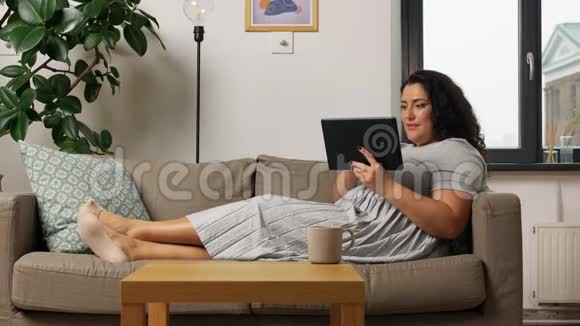 家里沙发上有平板电脑的女人视频的预览图