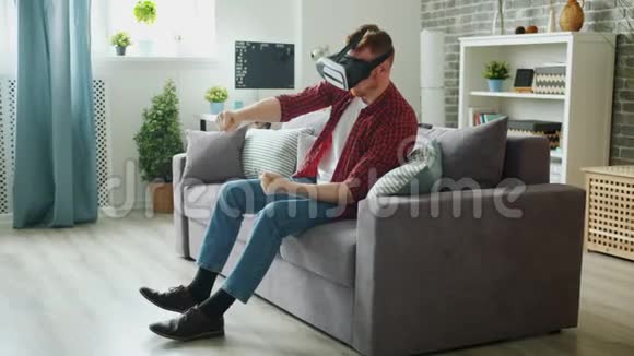 免费学生戴虚拟现实眼镜在家享受驾驶游戏视频的预览图