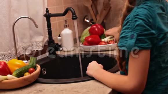小女孩在厨房洗手池洗蔬菜视频的预览图
