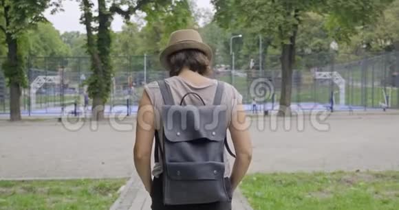 背景城市运动场篮球场公园里背着他的女人视频的预览图