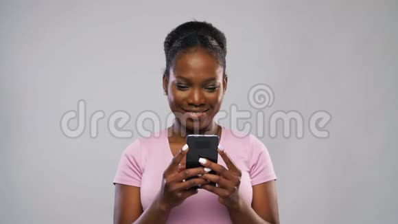 快乐的非裔美国女人使用智能手机视频的预览图