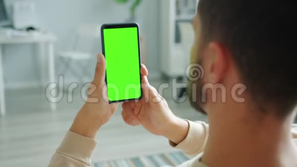 用绿色屏幕触摸浏览的男性手快速移动智能手机视频的预览图