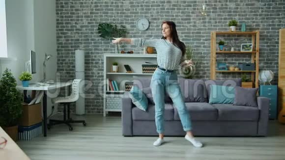 穿休闲服装的漂亮女孩独自在公寓里跳舞玩得开心视频的预览图