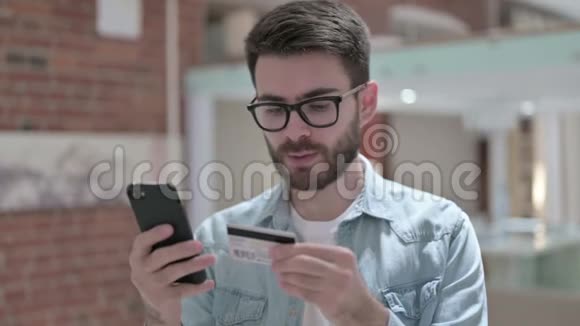 年轻男性设计师在智能手机上在线支付的画像视频的预览图