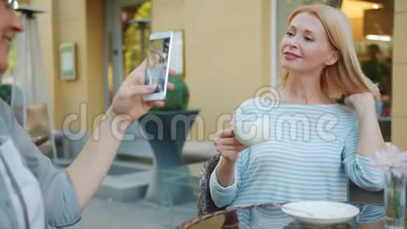 快乐女人在户外咖啡馆拍金发美女慢镜头视频的预览图