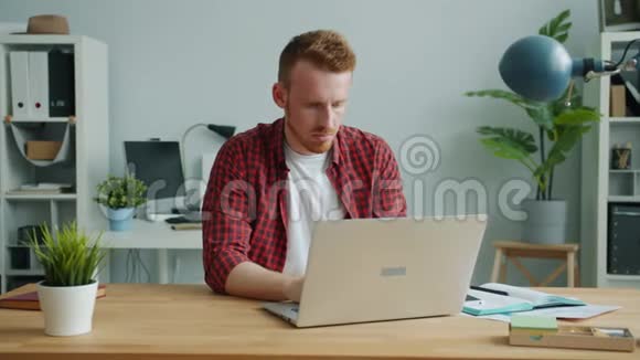 在办公室用电脑工作的老姜头发的家伙感到头痛视频的预览图
