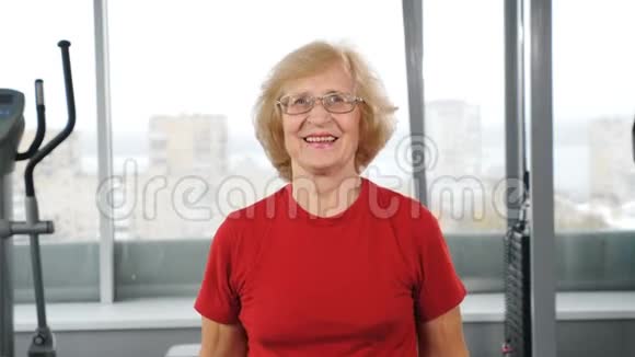 在健身房举起杠铃的老女人活跃快乐的晚年积极的退休人士进行轻操视频的预览图