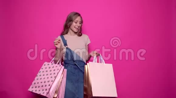 快乐而快乐的女孩打开五颜六色的购物袋视频的预览图
