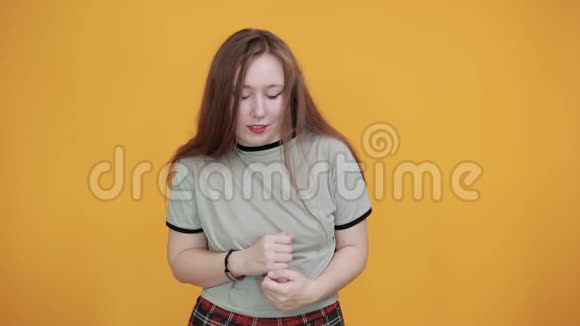 女子双拳交叉没有在隔离的橙色墙上做手势视频的预览图