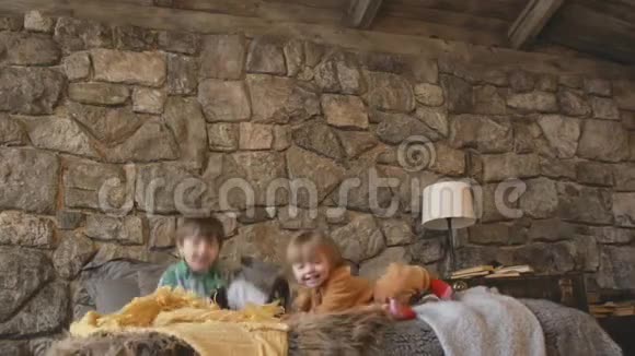 两个孩子蹒跚学步在床上跳跃幸福的概念视频的预览图