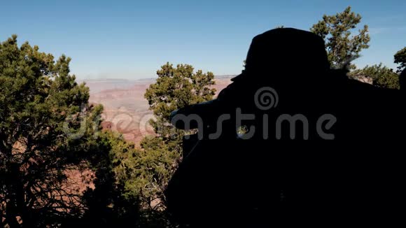 一位游客用望远镜观察大峡谷的剪影视频的预览图