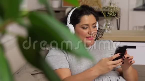 戴耳机的女人用智能手机听音乐视频的预览图
