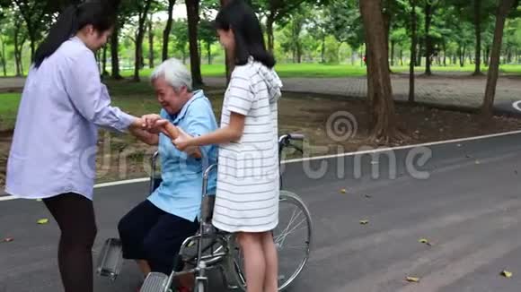 亚洲孙女女儿支持帮助高年级妈妈从轮椅上站起来练习走路快乐的老年病人w视频的预览图