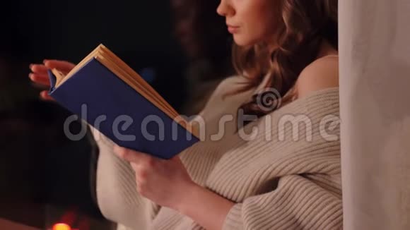坐在窗前看书的年轻女子视频的预览图