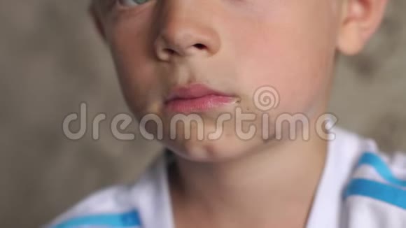 一个肮脏的小男孩的脸的特写镜头那孩子在街上玩得脏兮兮的视频的预览图