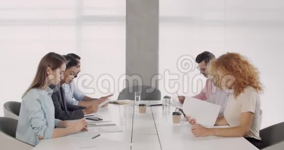 30多岁的英俊男性CEO走进办公室会议室听到好消息办公室工作人员的欢乐视频的预览图