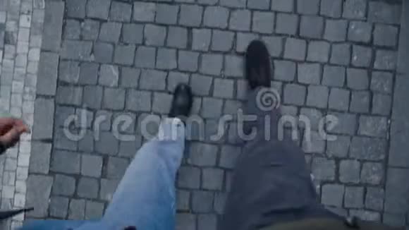 一男一女沿着鹅卵石铺成的街道走从上面看只有腿视频的预览图