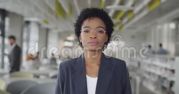 戴眼镜站着看镜头的漂亮女上班族的肖像年轻的非洲裔美国妇女视频的预览图