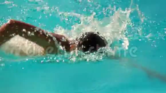 男孩在游泳池里以爬行的方式游泳视频的预览图