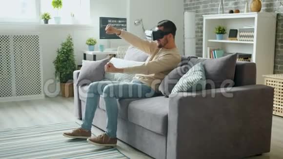 快乐的人玩游戏虚拟现实护目镜享受驾驶体验视频的预览图