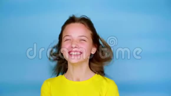 穿着黄色t恤的快乐少女用手捂住脸笑个不停视频的预览图