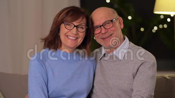 快乐的老夫妇在家沙发上拥抱视频的预览图