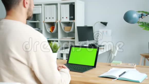 商务人士在现代办公环境中使用绿色屏幕色度键笔记本电脑视频的预览图
