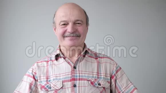 西班牙裔秃头老人用手显示心脏体征视频的预览图