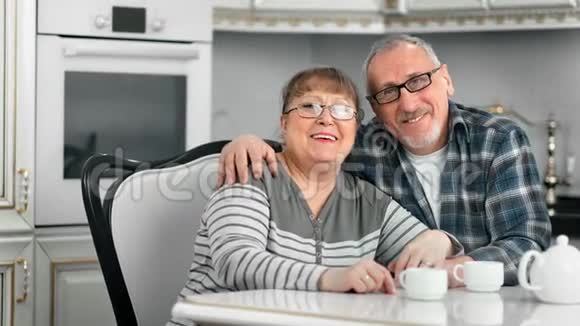 友好的老年家庭拥抱享受咖啡休息一起放松在白色美食内部视频的预览图