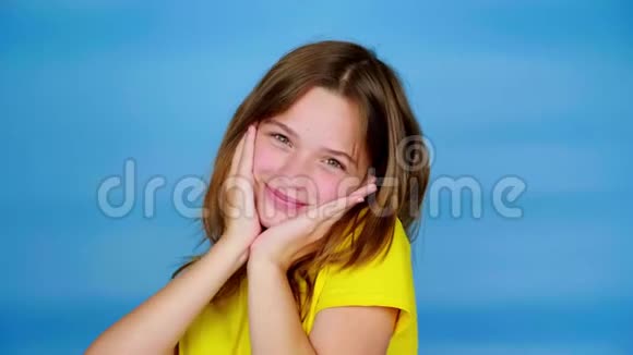 穿着黄色T恤的快乐少女面对面地牵手微笑着摆姿势看着镜头视频的预览图