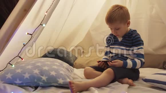 小男孩在家里孩子们的帐篷里玩快乐的白种人小孩在游戏室视频的预览图