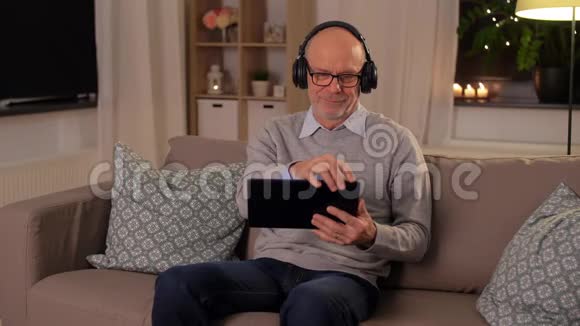 家里有平板电脑和耳机的老人视频的预览图