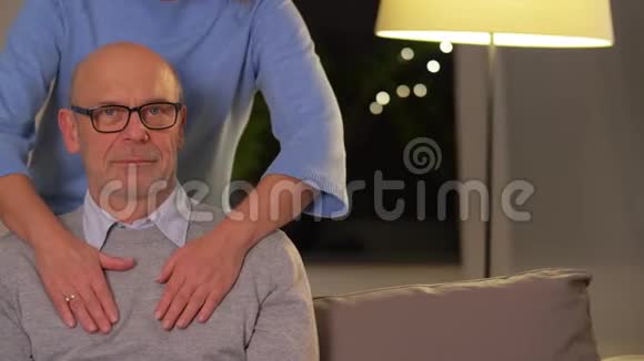 快乐的老夫妇在家沙发上拥抱视频的预览图