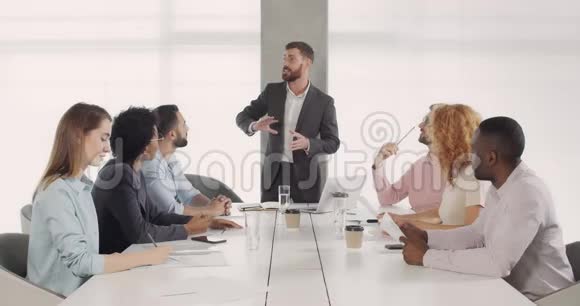 英俊的白种人首席执行官向会议室的同事们介绍了新的商业战略男性酋长视频的预览图
