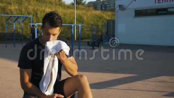 运动员用毛巾擦汗坐在长凳上视频的预览图