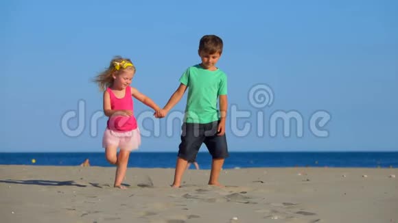 小男孩和小女孩在海滩上散步视频的预览图